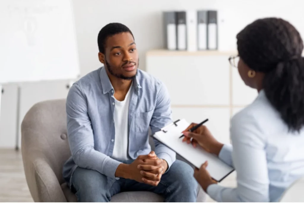 Therapist meeting with a client during a rational emotive behavior therapy session focused on identifying and changing irrational beliefs and emotional patterns that contribute to addiction.