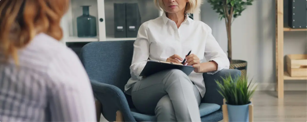 Addiction treatment professional conducting a confidential one-on-one counseling session in a private office.